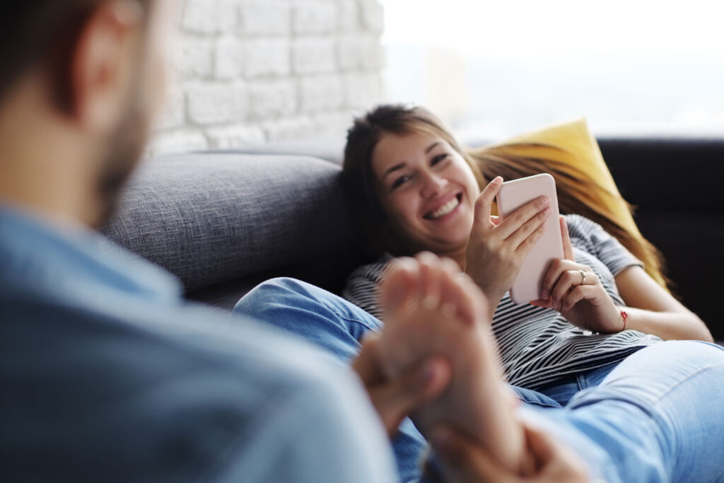 man massaging his girlfriends foot at home, back of the heel pain home remedy.