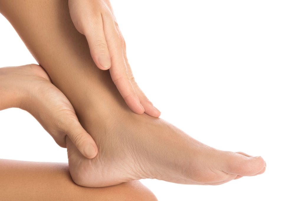 Woman touching her injured ankle.