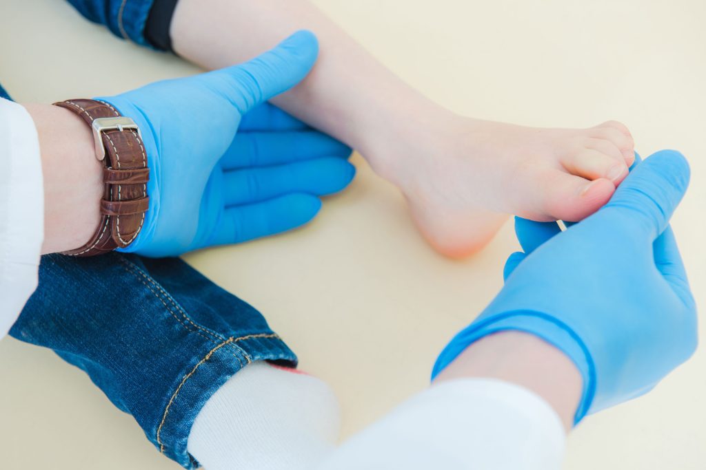 Woman with heel pain being examine by a podiatrist.