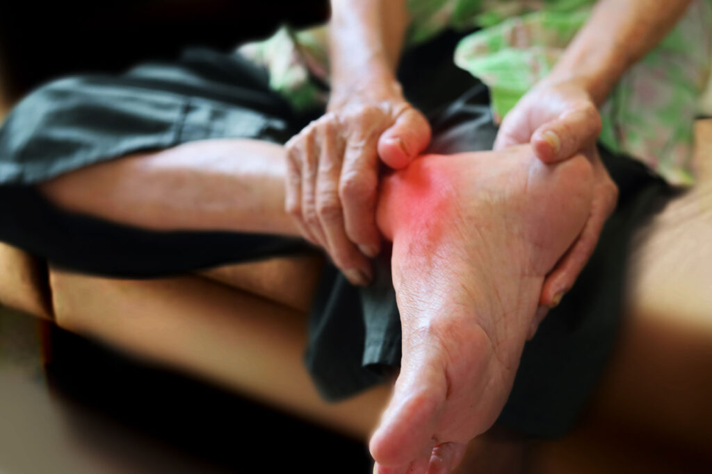 Elderly person holding his foot due to heel pain