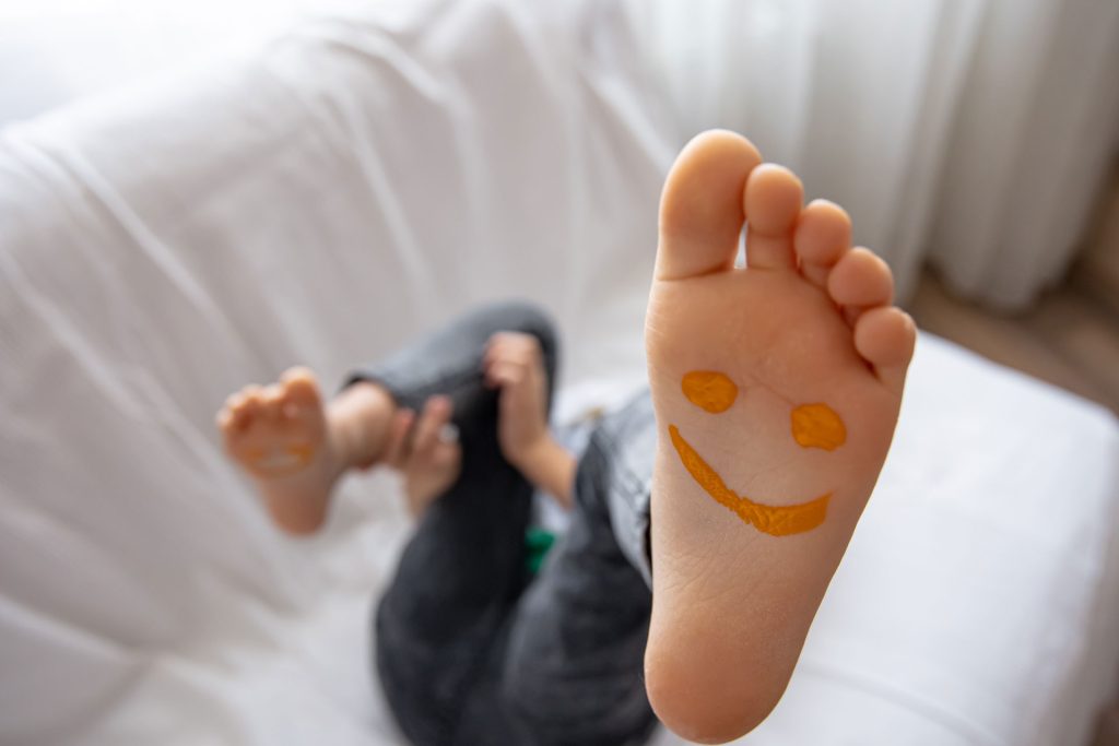 Close up photo of a woman feet with smiley drawing.